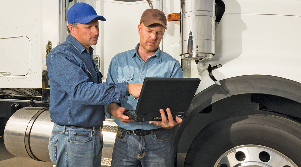 truck drivers conferring over a laptop