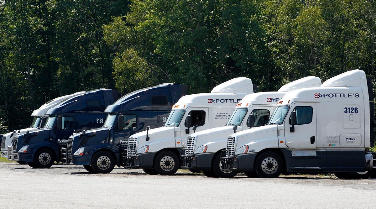 Trucks belonging to Pottle's Transportation sit on a lot in Bangor, Maine