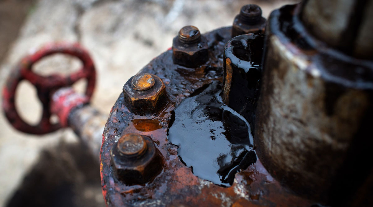 Thick black oil sits on the pipe work fitting of an oil pumping jack. (Andrey Rudakov/Bloomberg News)