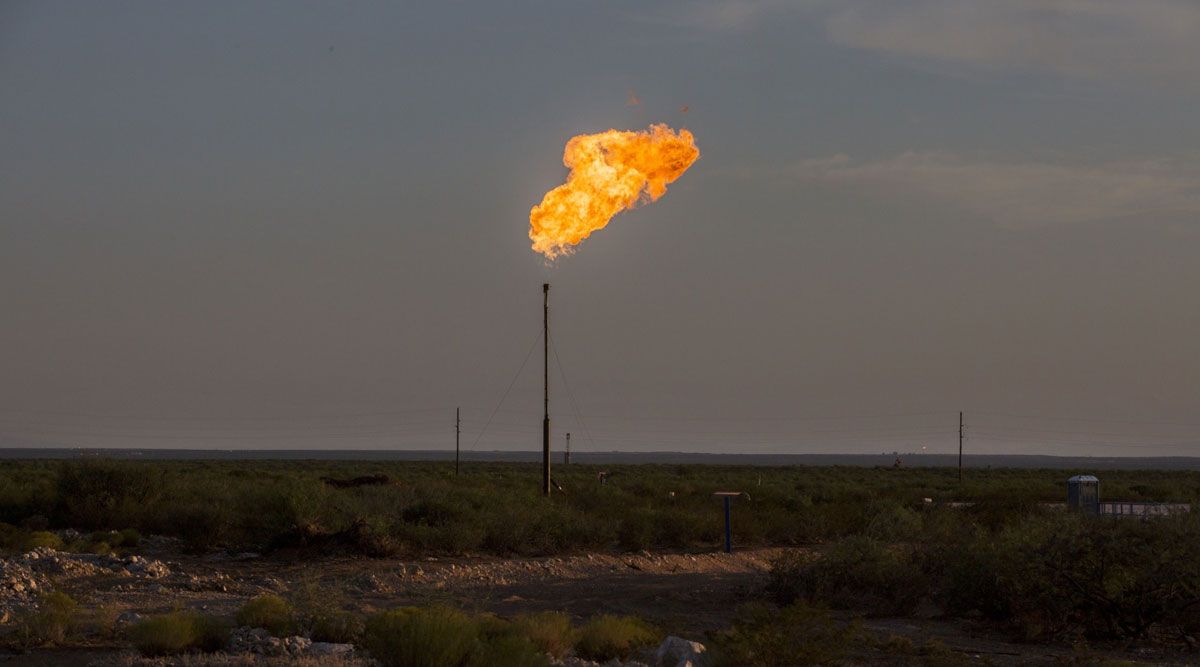 A gas flare is seen in a field near Mentone, Texas, in August 2019.