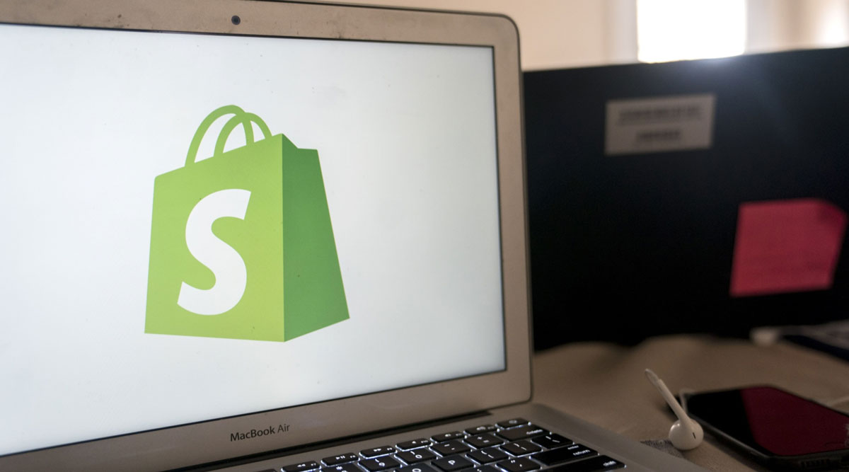 The Shopify logo is displayed on a computer.