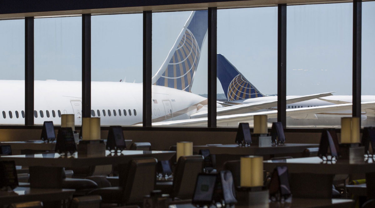 United Airlines planes stand past an empty waiting area for travelers at Newark International Airpor