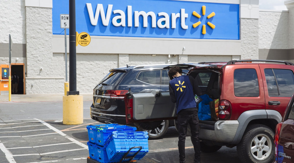 A worker delivers groceries to a customer's vehicle outside a Walmart store in New York on May 15.