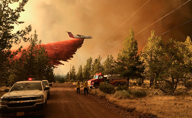 A firefighting tanker makes a retardant drop over the Grandview Fire near Sisters, Ore.