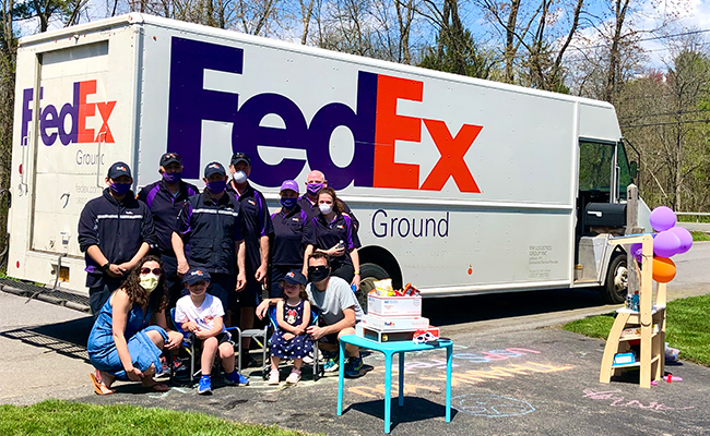 FedEx drivers pose with the Mahar family at their home in Niskayuna, N.Y.