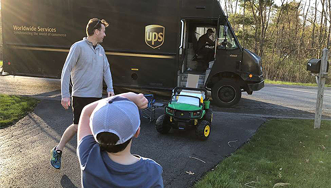 Jack Mahar, 5, and his father Shane welcome a UPS driver to their Niskayuna, N.Y., neighborhood.