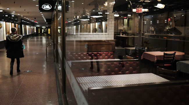 A shopper walks by a closed restaurant inside Rockefeller Center in New York on Dec. 20.