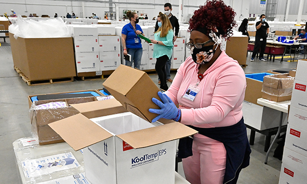 A McKesson employee packs a box of the Johnson & Johnson COVID-19 vaccine for shipping from their facility in Shepherdsville, Ky. 