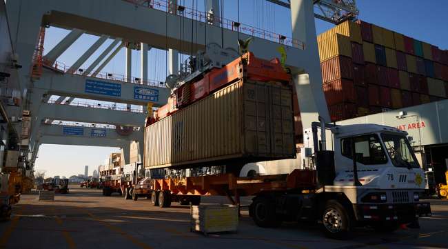 Shipping containers are loaded onto trucks