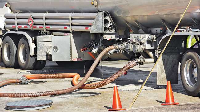 Tanker truck delivers fuel at a filling station