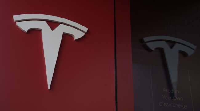 A Tesla Inc. logo outside of a closed showroom