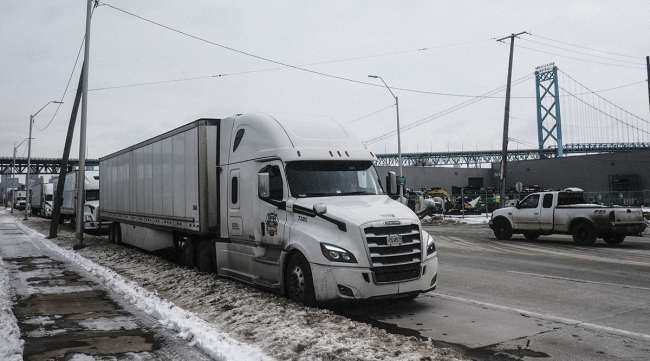 Trucks wait on the side of a road for the re-opening of Ambassador Bridge in Detroit