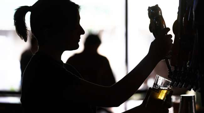 A bartender pours a beer