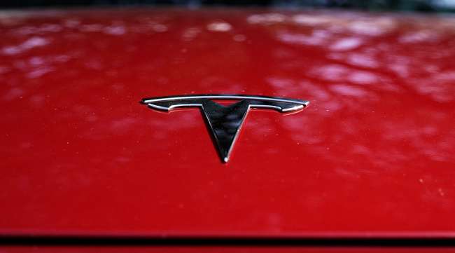 A Tesla logo is seen on a vehicle on display