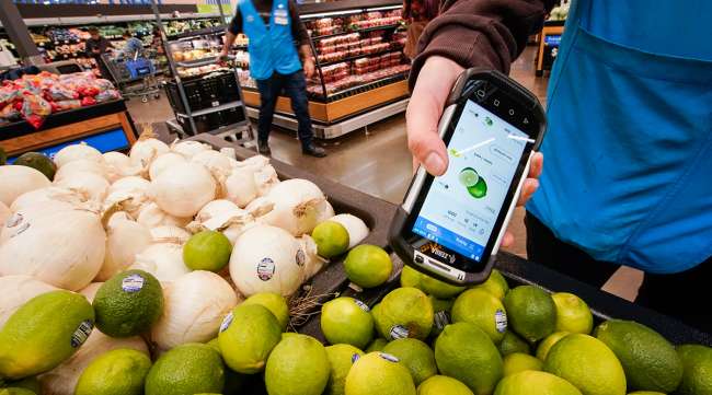 A worker scans onions, limes, and other produce inside a Walmart Supercenter