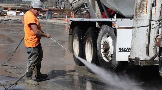 worker cleans cement truck