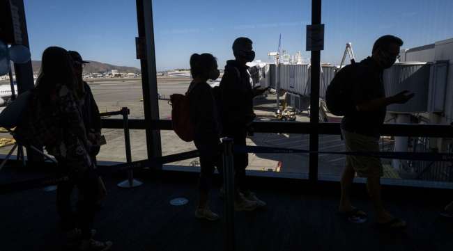 Travelers board a flight in San Francisco on Oct. 15.