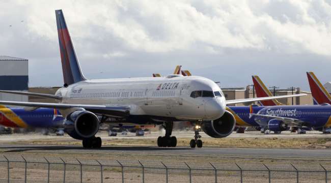 A Boeing 757-232 aircraft operated by Delta Air Lines taxis past Southwest Airlines planes in Victorville, Calif., on March 23.