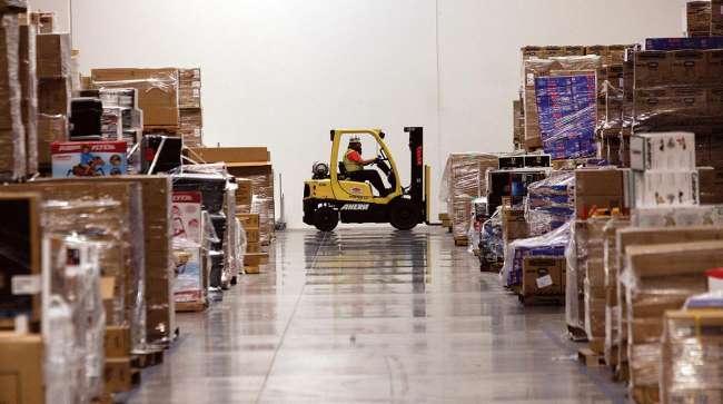 A worker drives a forklift past merchandise at the Amazon.com Phoenix Fulfillment Center in Goodyear, Ariz.