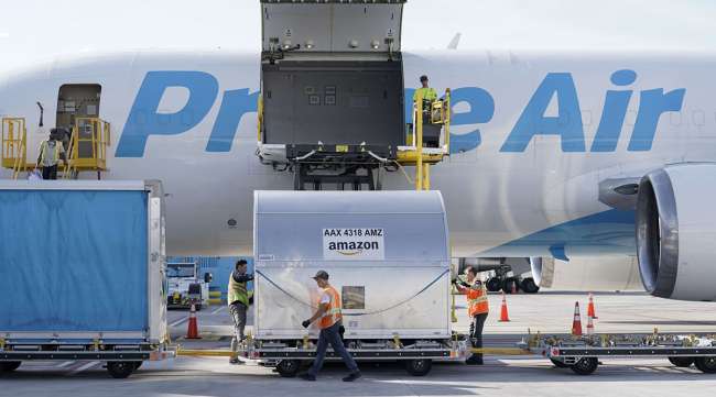 Grounds crew members load cargo into an Amazon Prime Air aircraft