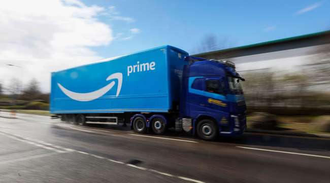 A truck featuring the Amazon Prime logo heads toward a fulfillment center in the United Kingdom on March 30.