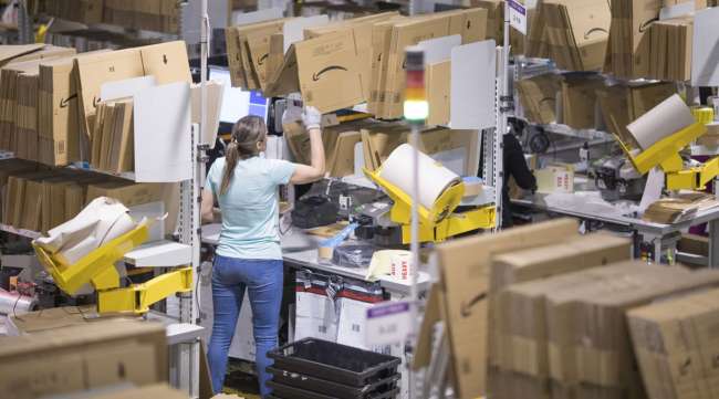 An employee packs boxes at an Amazon fulfillment center.