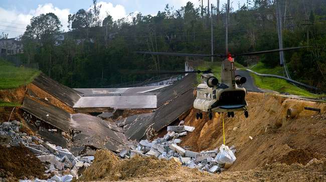 A U.S. Army helicopter transports material to repair the Guajataca Dam