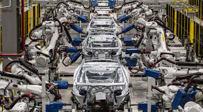 Robotic arms work on the body frames of sedans at an automaker's factory in Haiphong, Vietnam