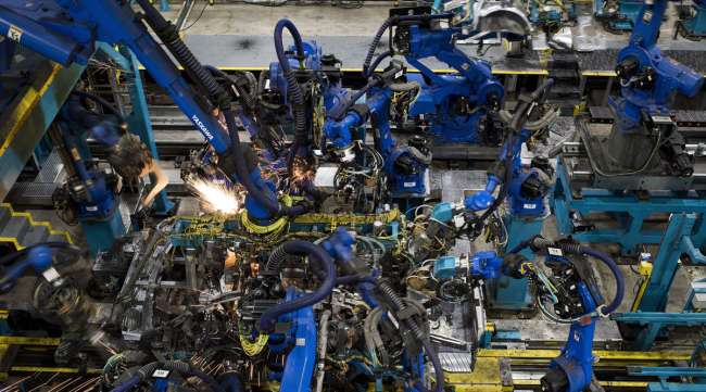 Sparks fly as robotic arms work on 2018 Honda Accord vehicles at a factory in Ohio in late 2017.