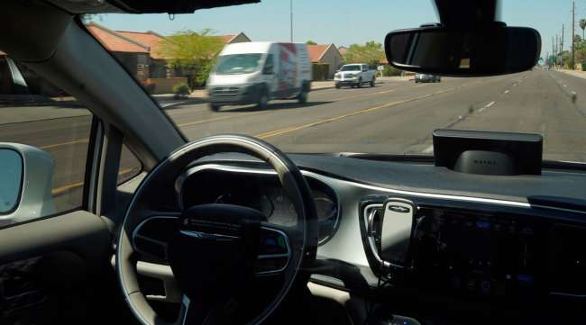 A Waymo minivan moves along a city street with an empty driver's seat in Chandler, Ariz. (Ross D. Franklin/Associated Press)
