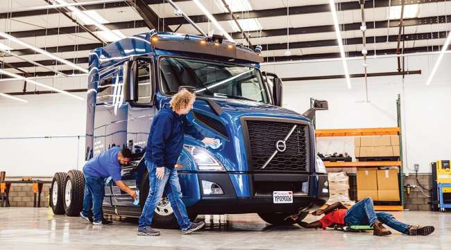 Workers clean an autonomous Embark truck