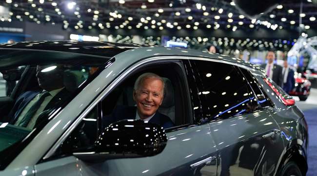 President Joe Biden drives a Cadillac Lyriq through the showroom during a tour at the Detroit Auto Show