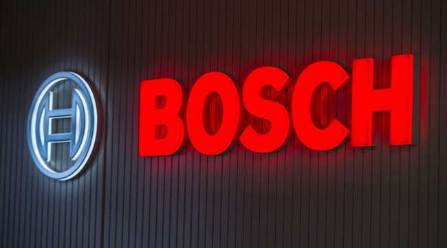 The Bosch logo sits illuminated on a wall at the Robert Bosch GmbH digital factory in Stuttgart, Germany