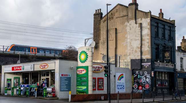 A train passes a BP Plc petrol station in London