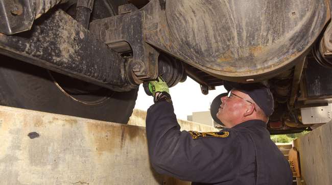 CVSA inspector checks brakes