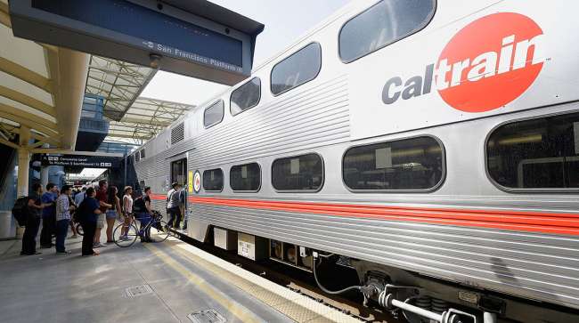 Commuters board a Caltrain car at the transit station in Millbrae, Calif.
