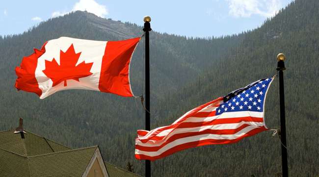Canada, USA flags blowing in wind