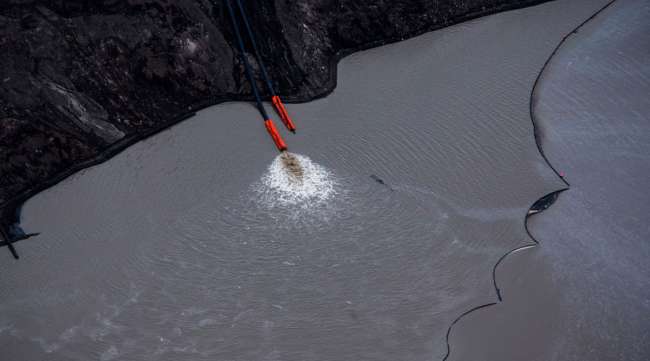 Water is pumped into a tailings pond at the Suncor Energy Steepbank mine in Fort McMurray, Alberta, in September 2018.