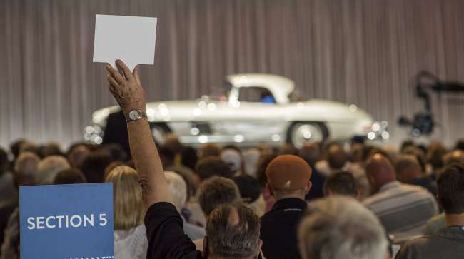 A bidder makes a bid on a 1957 Mercedes-Benz AG 300 SL Roadster during the Gooding and Company auction during the  Pebble Beach Concours d'Elegance in Pebble Beach, Calif.
