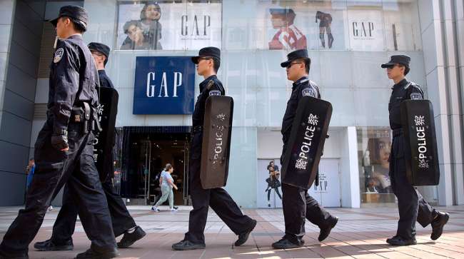 Beijing police patrol in front of a Gap store