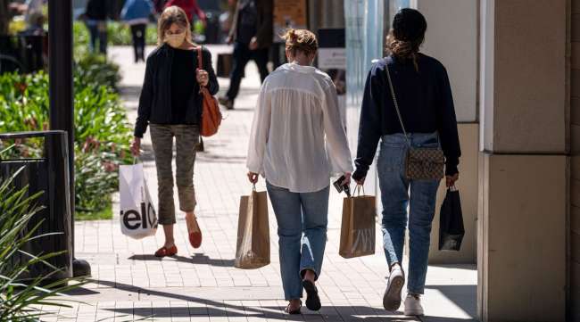 Shoppers wearing protective masks carry bags in Walnut Creek, Calif., in April. (Bloomberg News)