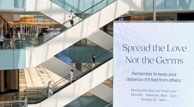 A "Spread The Love Not The Germs" sign is displayed at a mall in Dallas.