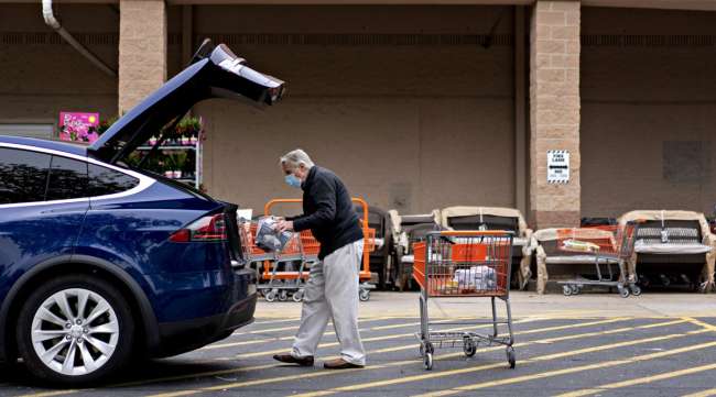 A customer wears a protective mask while loading purchases from a Home Depot store in Reston, Virginia, on May 21.