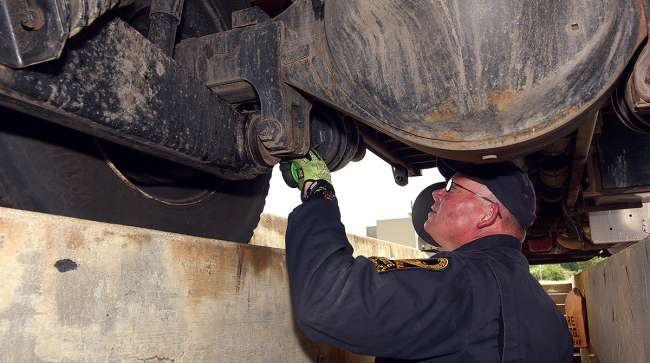 CVSA inspector checks brakes