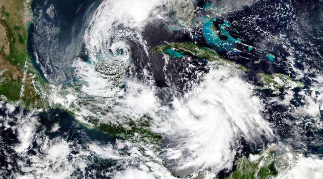 An Oct. 5 NASA satellite image shows the close proximity of Tropical Storm Gamma, left, and Hurricane Delta, lower right.