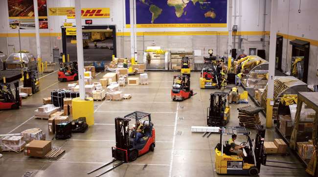 Forklifts move cargo at a DHL Worldwide Express hub