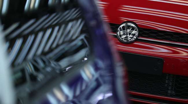 A Volkswagen AG badge adorns a new car in a VW factory in Germany.