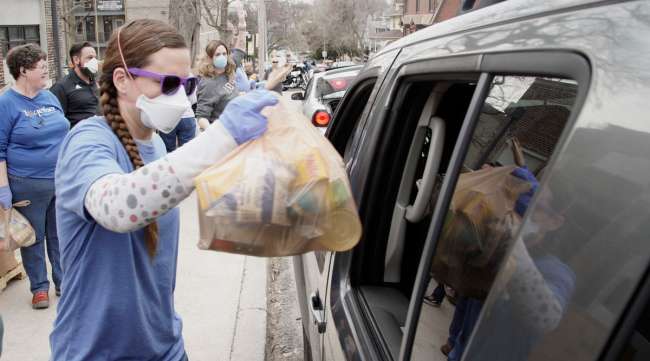 Food bank workers distribute food at a drive-through location in Omaha, Neb., on March 31.