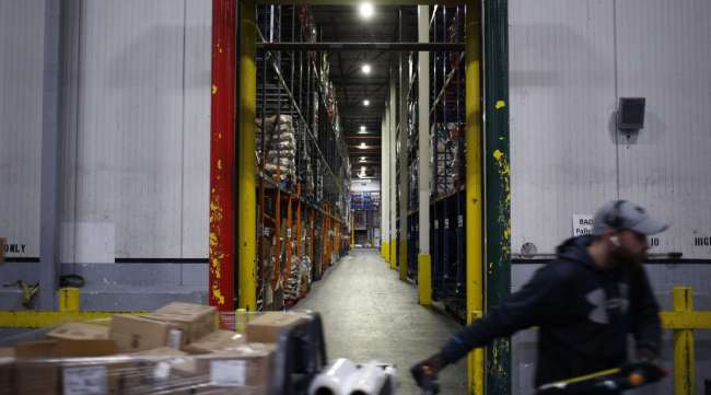 A worker drives a forklift through a grocery distribution center in Louisville, Ky.