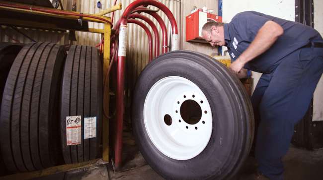Worker checks truck tires